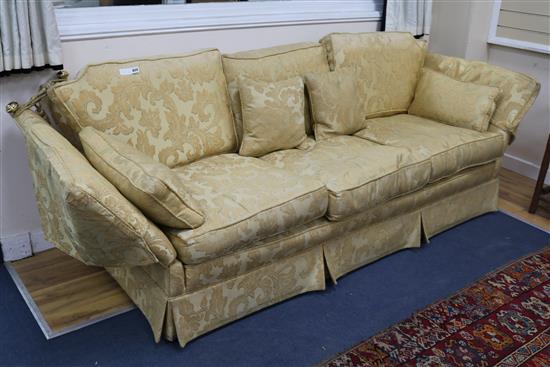 A three seater Knole-style settee in golden foliate patterned fabric W.244cm